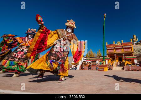 Mönche der Gelugpa tragen während des Diskit-Gustor-Festivals im Innenhof grimmige Masken und leuchtende Gewänder. Stockfoto