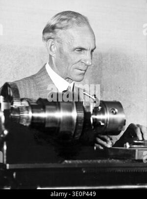 Dieses Schwarzweiß-Foto aus den 1930er oder 1940er Jahren zeigt den amerikanischen Industriellen Henry Ford, Gründer der Ford Motor Company, der mit Maschinen arbeitet. Er wird im Profil gezeigt, in einem Anzug gekleidet, wobei seine Hände in der Nähe von mechanischen Komponenten sichtbar sind, was seine lebenslange Beschäftigung mit Technik und Fertigung widerspiegelt. Stockfoto