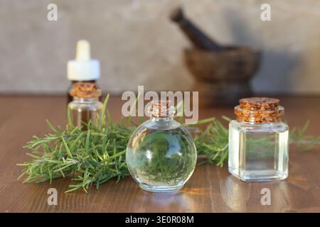 Ätherisches Rosmarinöl in Glasflasche auf Holz Stockfoto