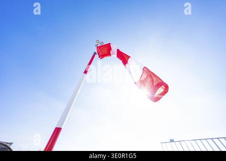 Eine rot-weiße Windsocke unter blauem Himmel und heller Sonne auf einem Flugplatz, Heliport des neuen Calw Krankenhauses, Bezirk Calw, Deutschland Stockfoto