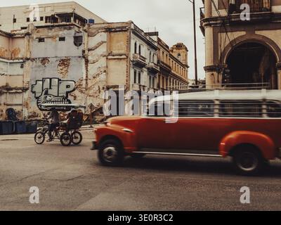 Havanna, Kuba, 24. Januar 2026 ProSportFoto-Tony Lewis. Oldtimer und Fahrrad in einer Straße mit abblätternden Gebäuden und Street Art Stockfoto