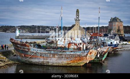 Blick aus der Vogelperspektive auf verwitterte Boote in der Nähe des Vauban-Turms und der Kapelle Notre Dame de Rocamadour, die die reiche maritime Geschichte der Stadt, Camaret, zeigen Stockfoto