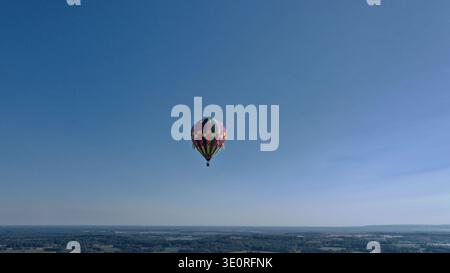 Luftaufnahme eines einzelnen Heißluftballons, der anmutig gegen die riesige azurblaue Leinwand des Himmels schwebt, Huntsville, Alabama, USA. Stockfoto