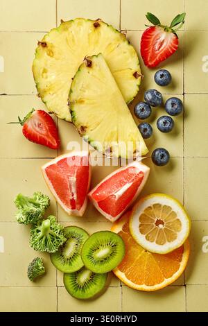 Blick von oben auf Vitamin-C-reiche Früchte und Gemüse einschließlich Orange, Zitrone, Kiwi, Erdbeeren, Grapefruit, Heidelbeeren, Ananas und Brokkoli Stockfoto