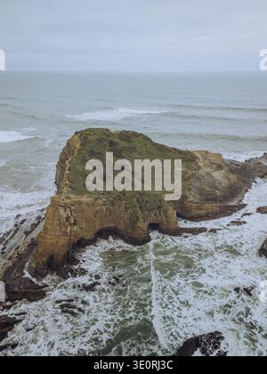 Aus der Vogelperspektive auf eine zerklüftete Küste, wo das Land auf das turbulente Meer trifft, Zambujeira do Mar, Bezirk Beja, Portugal. Stockfoto