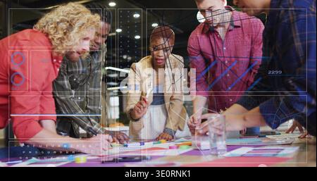 Führende Frau mit braunem Blazer, die das Team im Studio mit Papieren und HUD-Overlays um den Tisch führt Stockfoto