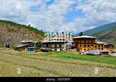 Häuser im traditionellen tibetischen Architekturstil mit Holzschnitzereien im Dorf Lobesa in der Nähe des buddhistischen Tempels der Fruchtbarkeit Chimi Lhakhang in Bhutan Stockfoto