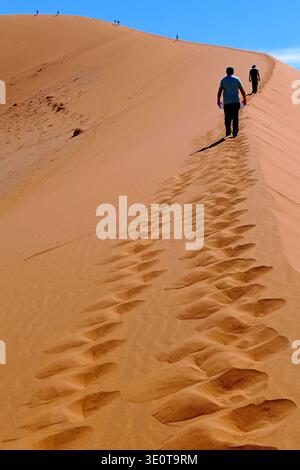Silhouetten von Menschen auf dem Kamm einer Sanddüne in Sossusvlei, Namibia Stockfoto