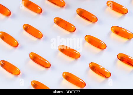 Muster der orangen Omega-3-Gelkapseln isoliert auf weißem Hintergrund, tägliches Gesundheits-Ernährungskonzept Stockfoto
