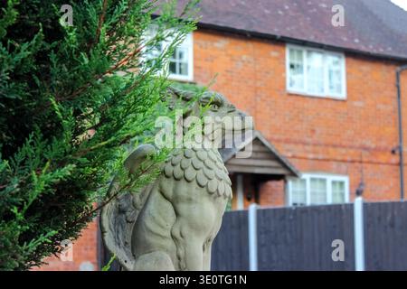 Eversley, Vereinigtes Königreich - 21. September 2025: Eine Steinstatue des griffins in einem Garten. Er hat einen Adlerkopf und einen muskulösen Körper mit Schuppen. Stockfoto
