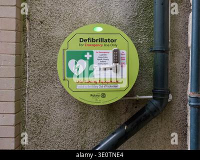 März 2026. Cockermouth, Cumbria, Vereinigtes Königreich.ggrA Defibrillator-Einheit, finanziert vom Rotary Club of Cockermouth, ist an einer strukturierten Wand montiert Stockfoto