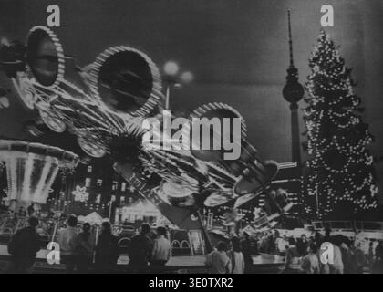 Ostberliner treffen sich gestern Abend vor einem lustigen Fass auf dem Ostberliner Weihnachtsmarkt. Der Markt im Hintergrund der Fernsehturm) ist Stockfoto