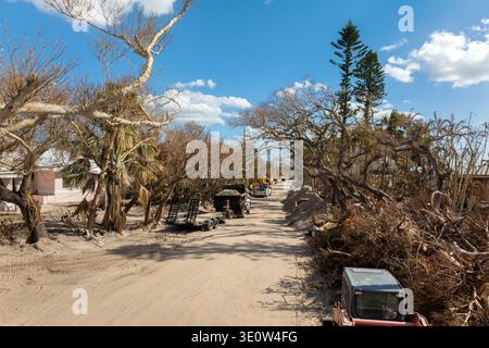 Müll aus schwer beschädigten Häusern nach Hurrikan Milton Sturmflut. Schutthaufen auf der Straßenseite der Manasota Key Street in Florida. Konsequenzen Stockfoto