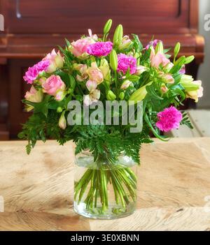 Vase, Blumenstrauß und Blumen zu Hause, Dekoration für Wohnzimmer und Klavier für Musik. Wohnung, Blumen und Rosen im Wasser, leer und blühen für Natur Stockfoto