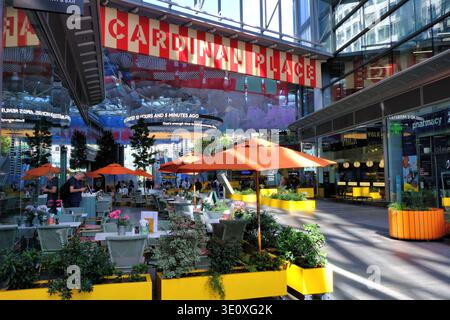 Geschäfte, Restaurants und informative digitale Four Winds-Displays im farbenfrohen Cardinal Place and Cathedral Walk, Victoria, London, Großbritannien Stockfoto