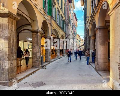 Borgo Stretto. Historische enge Straße mit Bogengängen und historischen Geschäften. Leute laufen in Pisa, Italien. Stockfoto