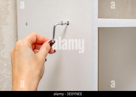 Montage einer Regaleinheit mit einem L-förmigen Inbusschlüssel. Stockfoto