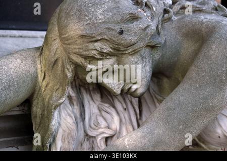 Die Statue einer Frau, die in einem Ausdruck der Trauer auf dem Wiener Zentralfriedhof – Wien, Österreich – über ein Grab gelegt wurde Stockfoto