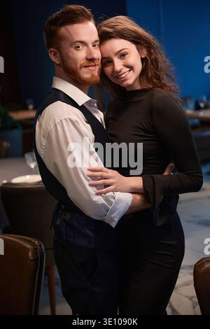 Pärchen, die abends im Restaurant lächeln Stockfoto