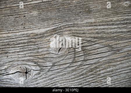 Eine Nahaufnahme alter Holzdielen, die komplizierte Muster und Texturen enthüllen. Die verwitterte Oberfläche zeigt Knoten und natürliche Körnung Stockfoto