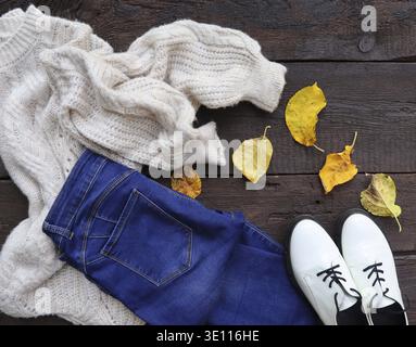 Herbst-Outfit für Damen. Set von Kleidung, Schuhen und Accessoires auf Holzhintergrund Stockfoto
