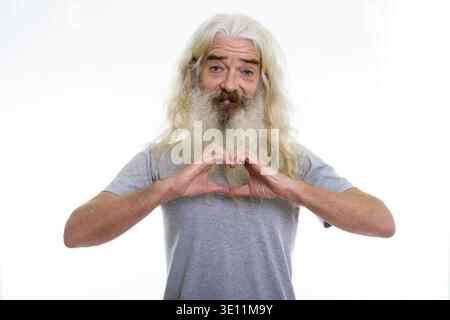 Studio shot von Happy älterer bärtiger Mann lächelnd, während sie Herz hand Zeichen Stockfoto