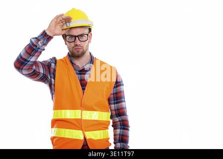Junge kahle muskulösen Mann Bauarbeiter holding Schutzhelm auf dem Kopf Stockfoto