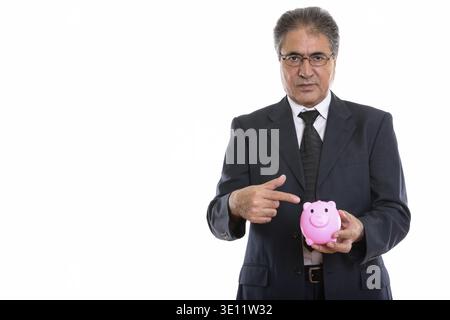 Studio shot der Persischen Kaufmanns Holding und zeigen auf piggy Bank Stockfoto