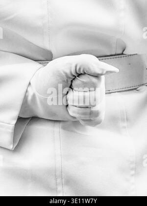 Eine Faust in einem weißen Handschuh wird hinter dem Rücken eines Soldaten in weißer Uniform geballt, während er während einer militärischen Zeremonie in Lima, P, bei der Parade ruht Stockfoto