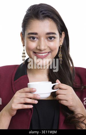 Gesicht der jungen indischen Unternehmerin glücklich lächelnd, während sie Kaffee Tasse Stockfoto