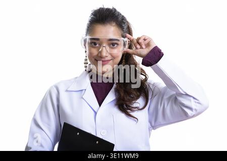 Junge schöne indische Frau Doktor tragen und halten Schutzbrille Stockfoto