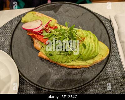 Los Angeles, CA - 13. März 2026: Avocado Toast Frühstück LAX Delta One Lounge Stockfoto