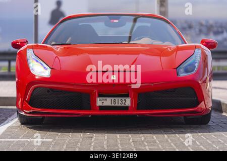 Vorderansicht eines roten Ferrari mit 488 GTB, der auf einem Parkplatz in Dubai geparkt ist und Luxus und Reichtum bietet Stockfoto