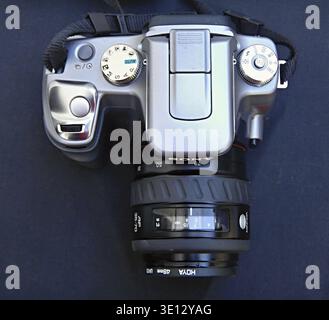 Digitale Spiegelreflexkamera mit einem Objektiv, die die Bedienelemente und das Objektiv auf dunklem Hintergrund zeigt Stockfoto