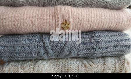 Ein Stapel warmer, kuscheliger Strickpullover für Damen. Komfortkonzept für Herbst oder Winter Stockfoto