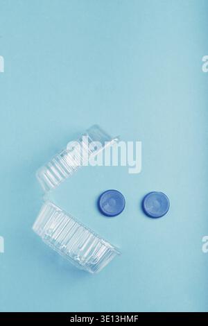 Kunststoffverpackung und Flaschenverschlüsse auf blauem Hintergrund. Sammlung von Kunststoffabfällen zum Recycling. Begriff der Kunststoffverschmutzung und zu viele Kunststoffabfälle Stockfoto