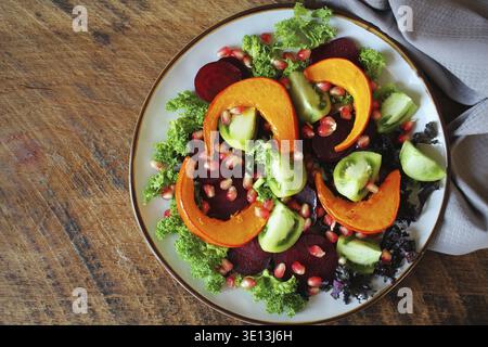 Gesunder vegetarischer Salat, gebratener Kürbis, Tomaten, Granatapfel, Grünkohl, Rübe Stockfoto