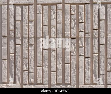 Eine Wand aus hellbraunem Ziegelstein. Die Ziegelsteine werden hintereinander gelegt. Stockfoto
