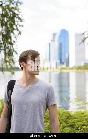Porträt junger stattlicher Mann mit Rucksack und entspannen Sie im Park Stockfoto