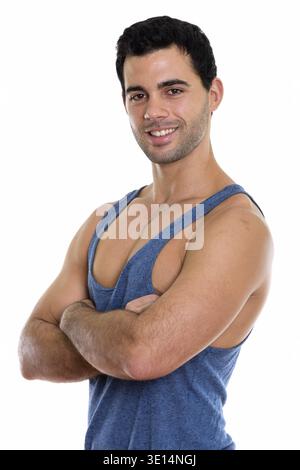 Studio shot der Jungen glücklich aussehenden Hispanic Mann lächelnd mit gekreuzten Armen Stockfoto