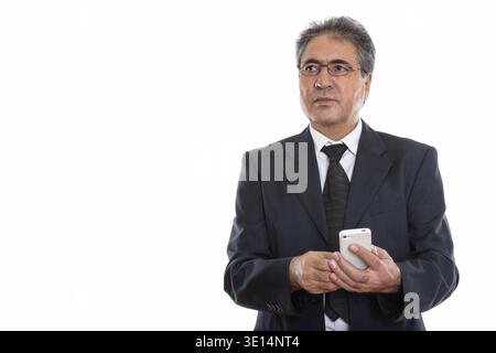 Studio shot der Persischen Kaufmanns holding Handy beim Denken Stockfoto