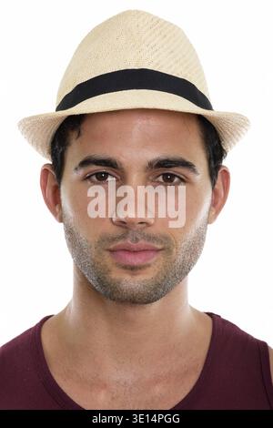 Gesicht der jungen Hübschen Hispanic Mann mit Hut vor weißem Hintergrund Stockfoto