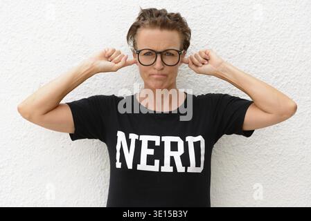 Porträt einer reiferen, schönen Nerdfrau, die im Freien eine Brille vor weißem Hintergrund trägt Stockfoto