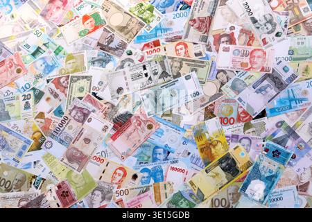 Viele Banknoten unterschiedlicher Währung. Eine große Menge von zufälligen Geldrechnungen aus der Nähe. Währungsumtausch-Konzept Stockfoto