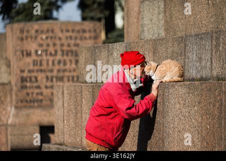St. Petersburg, Russland. März 2026. Ein Mann mit einer Katze auf dem Marsfeld in St. Petersburg. St. Petersburg hatte für Mitte März dieses Wochenende ungewöhnlich warmes Wetter. Die Temperaturen erreichten 15 Grad Celsius. Die Bewohner strömten auf die Straßen, füllten Parks, Dämme und zentrale Plätze. Quelle: SOPA Images Limited/Alamy Live News Stockfoto