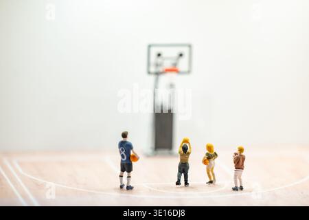 Miniaturbasketballspieler schießen auf dem Platz, kleine Leute spielen Sport Stockfoto