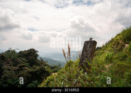 Tanah rata, Cameron Highlands, Malaysia – 27. Januar 2020: Concrete Trail 10 Markierer auf einem grasbewachsenen Hügel. Stockfoto