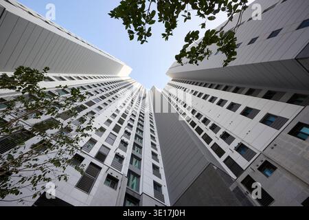 Zwischen hohen Gebäudefassaden in Richtung Himmel schauen. Stockfoto