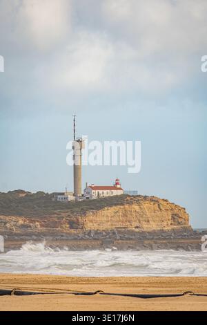 Ein malerischer Leuchtturm und Radarturm stehen auf einer Klippe in Portimao, Portugal. Die Szene fängt den dramatischen bewölkten Himmel der südlichen Re ein Stockfoto