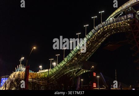 Ein beeindruckender Blick auf eine beleuchtete Industriemetallkonstruktion vor dem Nachthimmel in Peking. Das komplizierte Design und die lebendige Beleuchtung sorgen für ein capt Stockfoto